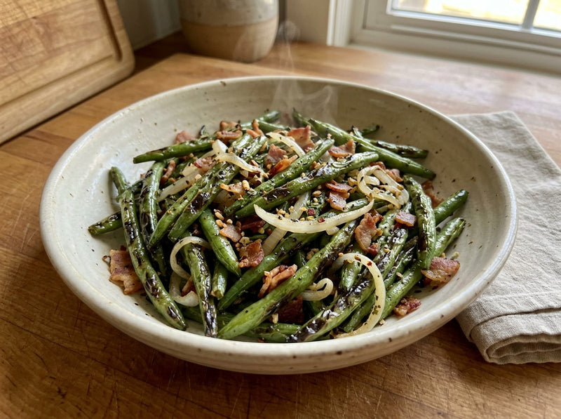 Blistered sautéed green beans with white onion and bacon in a serving bowl